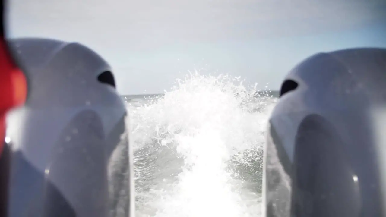 Boat cruising in the ocean with water closeup splashing in slow motion