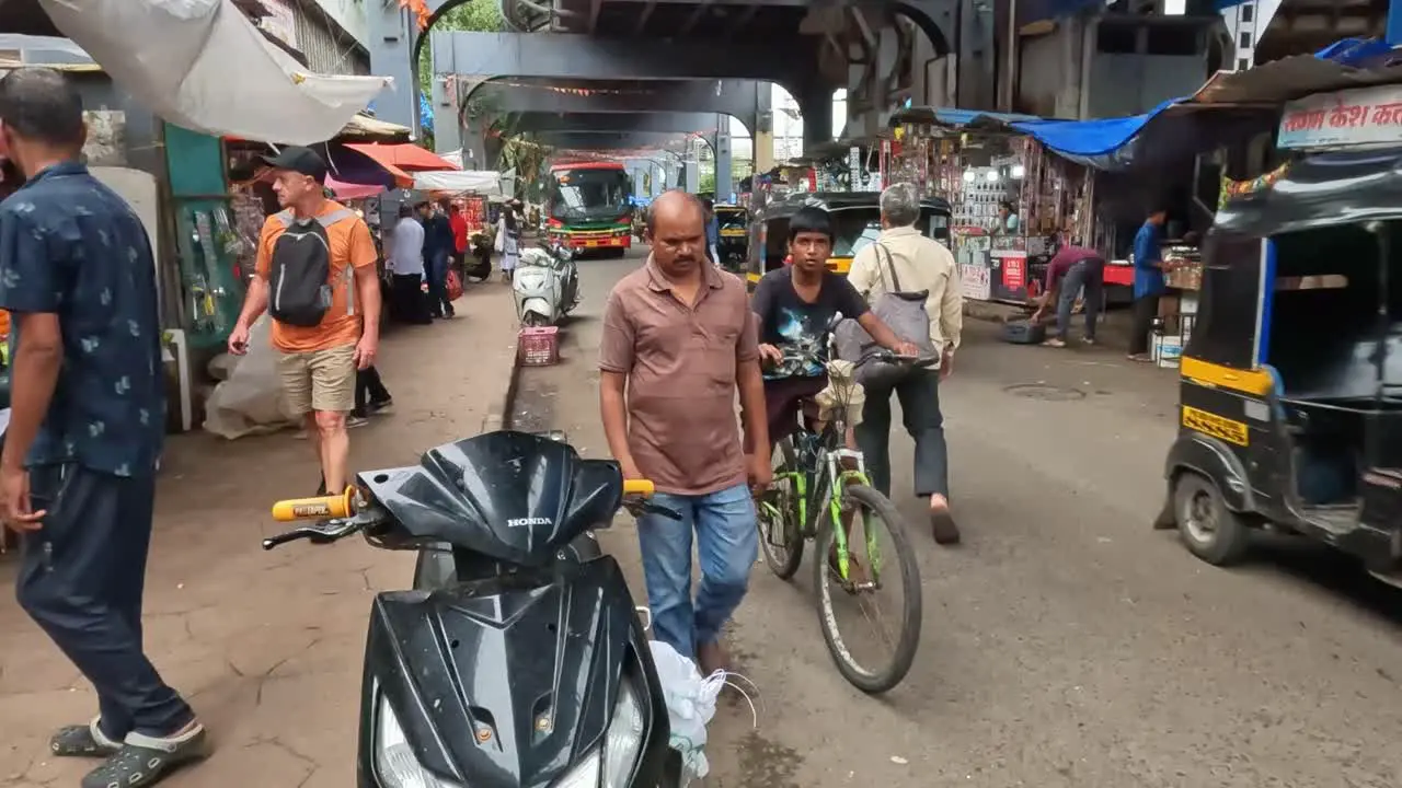 Mumbai India 20 August 2023 A busy thoroughfare with people and different types of vehicles in a market in Mumbai India