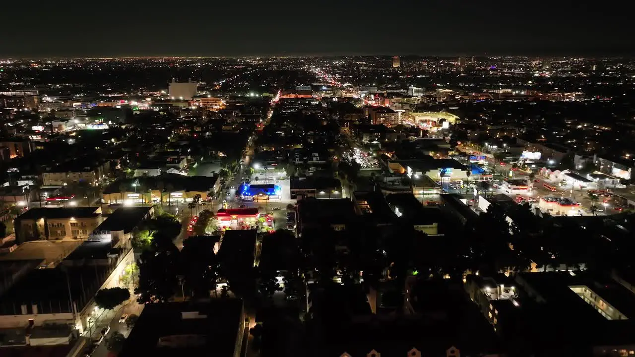 Aerial view flying across Hollywood Los Angeles night cityscape illuminated skyline