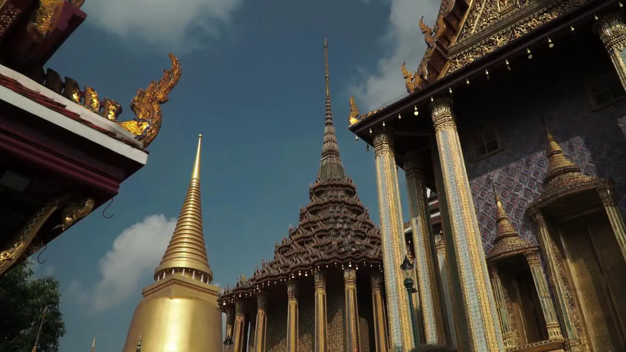 Tilting Upshot Tourists Gathering and Takes a photo of Emerald Buddha Temple Scenic view of Golden Pagoda in the background