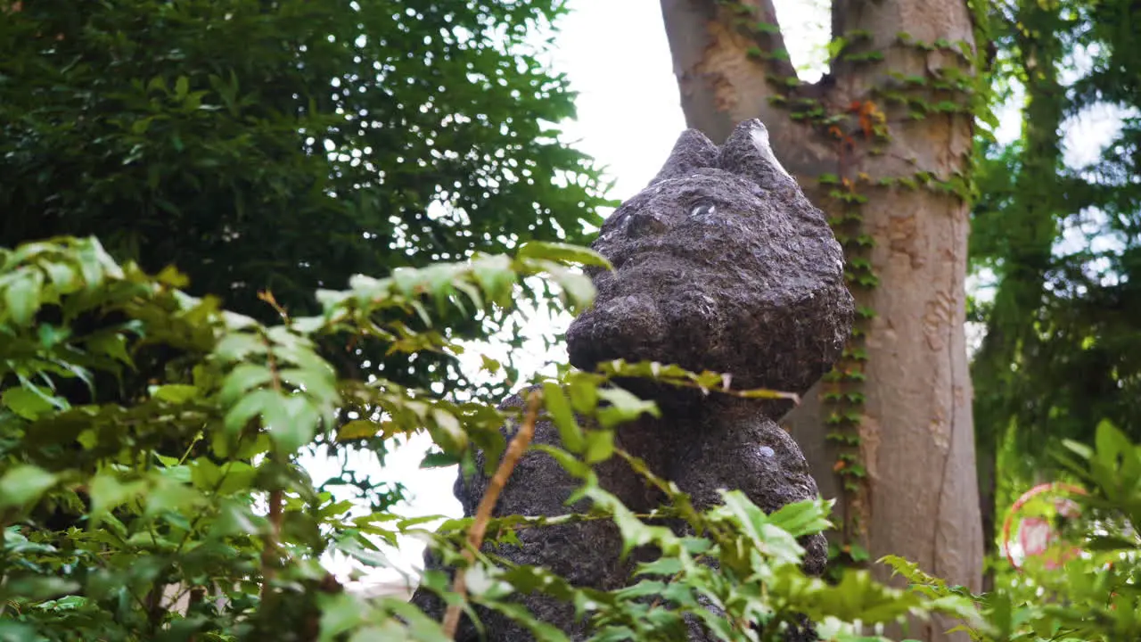 Japanese statue of mythical creature sits amongst nature in a peaceful green Tokyo park