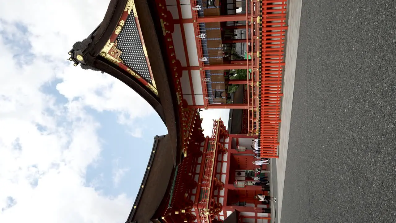 Tourists Walking Around Fukakusa Yabunouchicho With Tower Gate In Background At Fushimi Inari Shrine