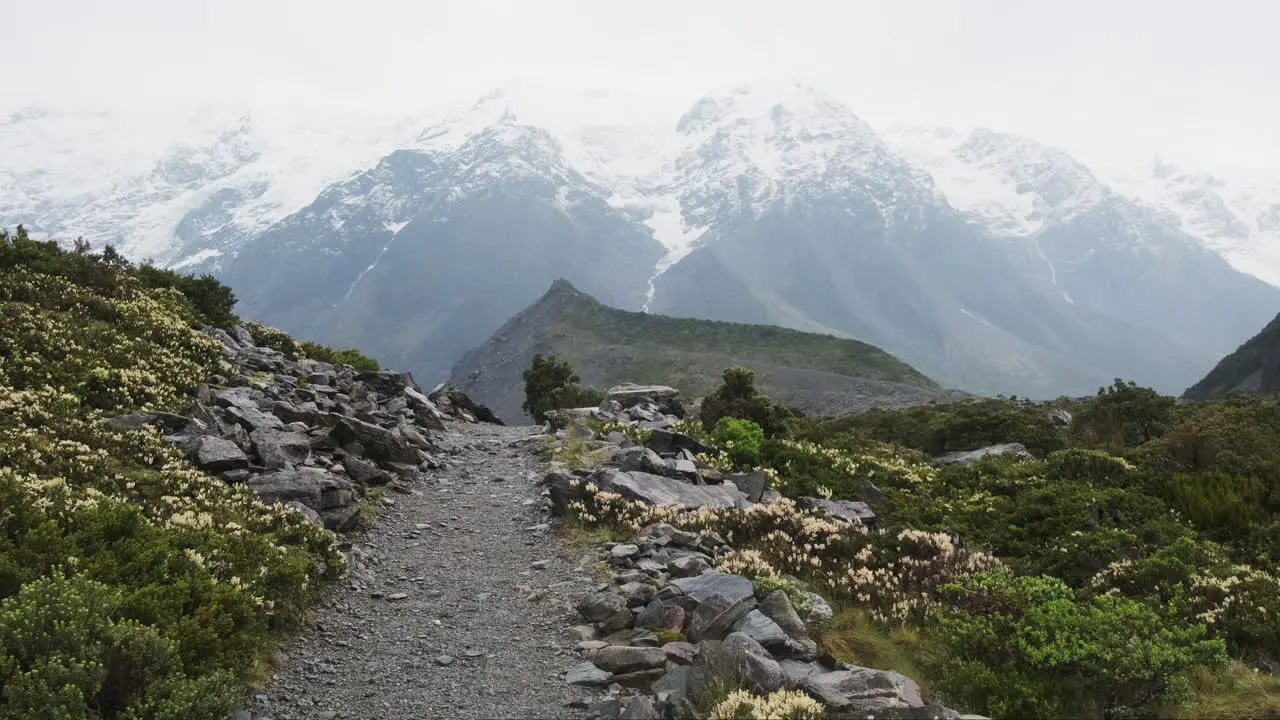 A beautiful hiking path with a view of a misty and snowy mountain in the background