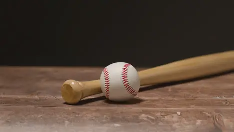 Close Up Studio Baseball Still Life With Wooden Bat And Ball On Wooden Floor