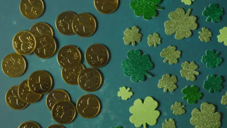 Overhead Studio Shot Of Gold Coins With Shamrock Symbol With Shamrock Shapes On Background To Celebrate St Patricks Day