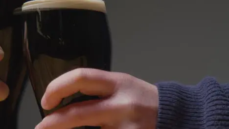 Close Up Of Two Pint Of Irish Stout In Glass Making A Toast To Celebrate St Patricks Day