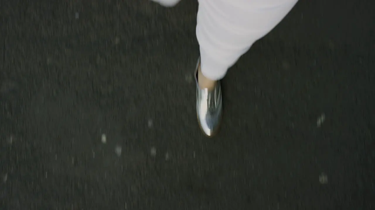 woman walking on asphalt road wearing stylish silver shoes strolling casual in city above view