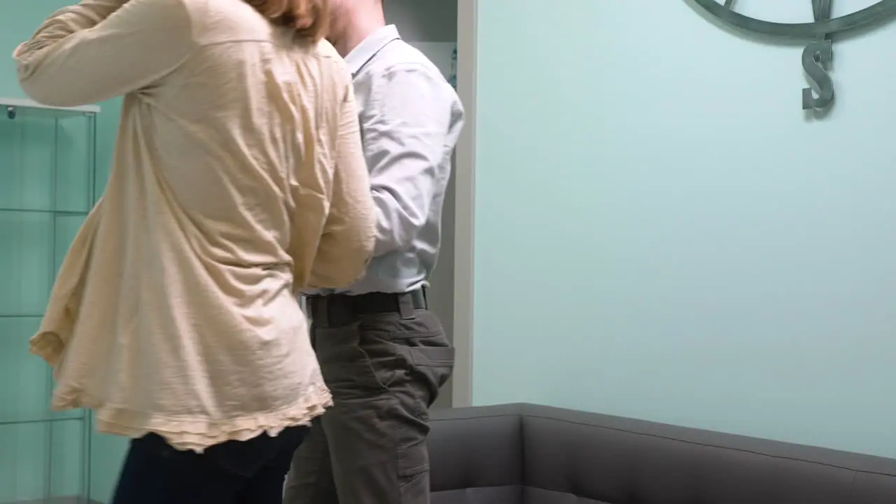 Pregnant Woman And Her Husband Sitting On Sofa Waiting For Gynecologist In Medical Consultation 1