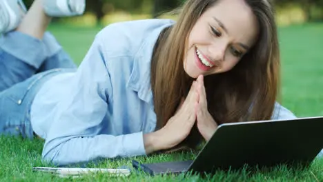 Happy woman looking at email with good news on laptop computer in park