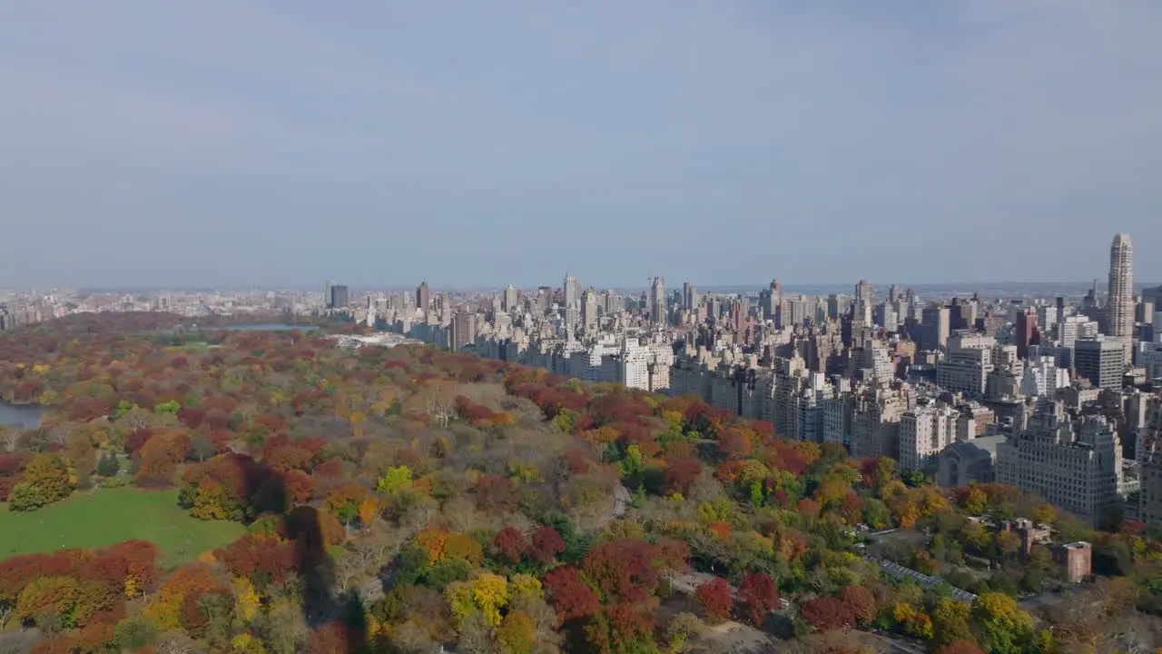 Aerial panoramic footage of large park with autumn colour trees and surrounding buildings Neighbourhoods around Central park Manhattan New York City USA