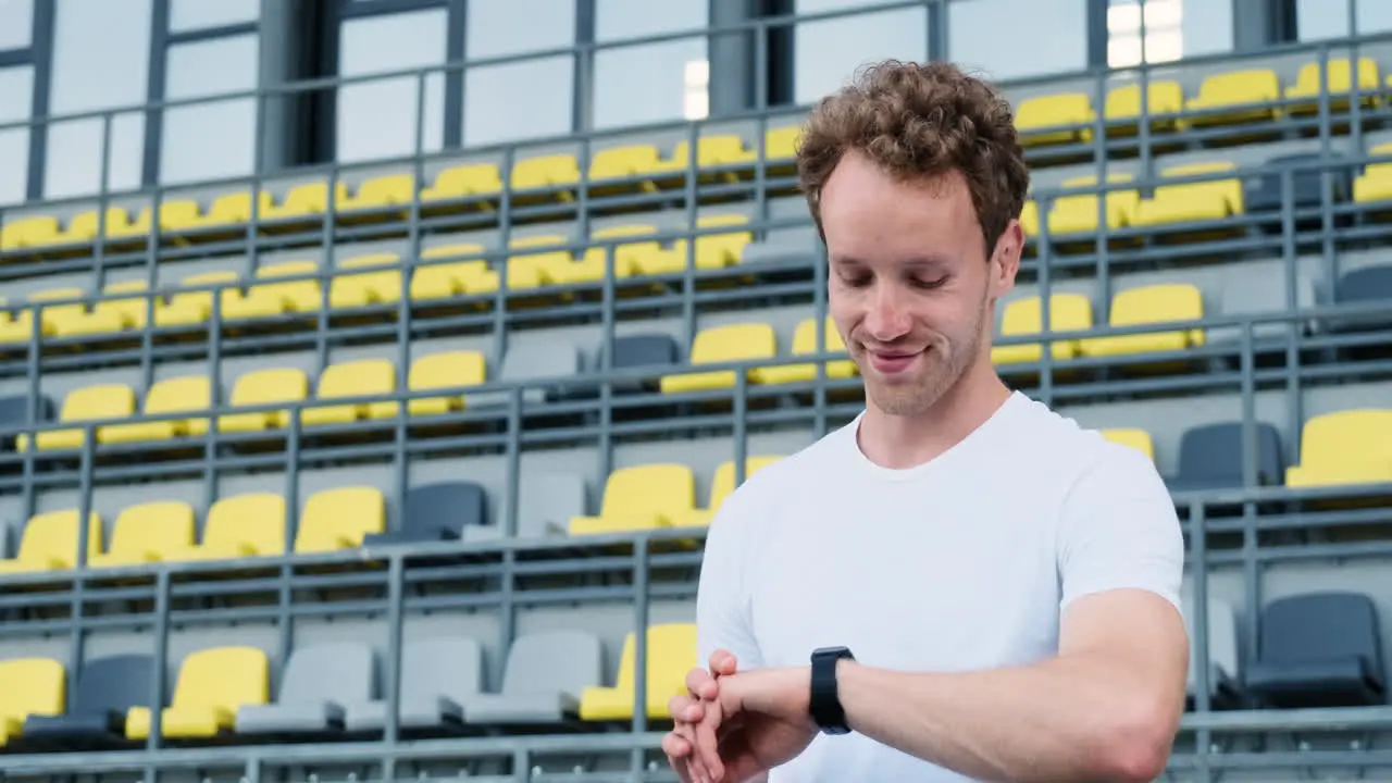 Happy Sportive Man Checking His Smartwatch Before Outdoor Training In The Stadium 1