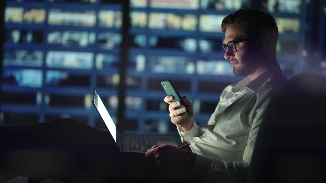 Office Building with Businessman Using Mobile Phone and Standing by the Office Window Man working in modern office late at night Busy caucasian manager at work with mobile telephone