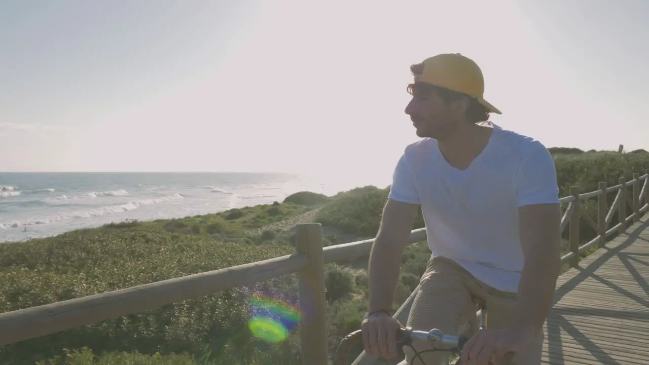 Ciclista Masculino En Un Paseo Marítimo Hacia La Playa Mirando Al Mar