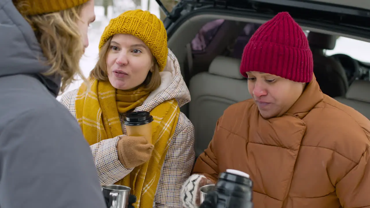 Fröhliche Freunde Die Während Einer Winterreise In Der Nähe Des Autos In Einem Verschneiten Wald Zusammen Trinken Und Reden