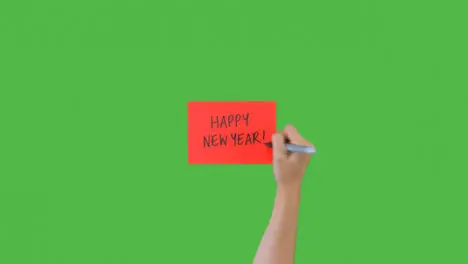 Woman Writing Happy New Year on Paper with Green Screen 02