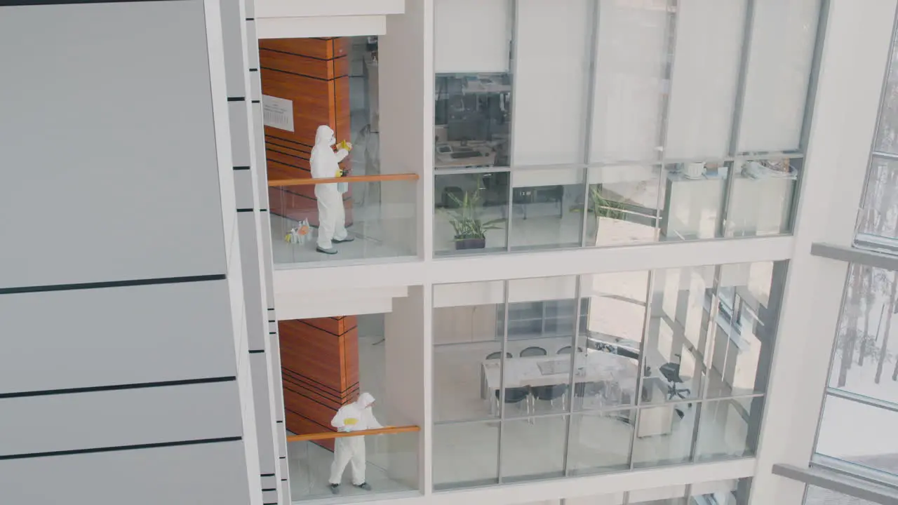 Vista Lejana De Dos Hombres De Limpieza Que Usan Equipo De Protección Personal Limpiando Barandillas De Escaleras Dentro De Un Edificio De Oficinas