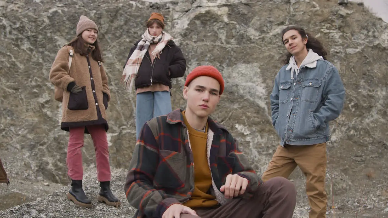 Vista De Cerca De Un Grupo De Amigos Adolescentes Vestidos Con Ropa De Invierno Posando Mirando La Cámara Sentados Y Parados En La Montaña