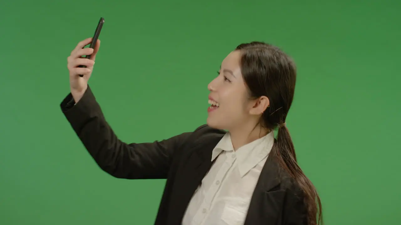 Smiling Businesswoman Taking Seflie on Green 