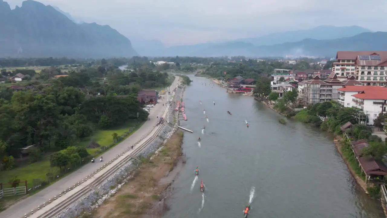 Aerial Flying over Nam Song River At Vang Vieng With longboats Going Past