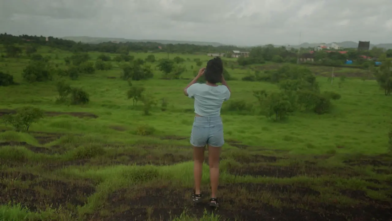 A joyful Indian young girl leaps energetically in a lush forest setting