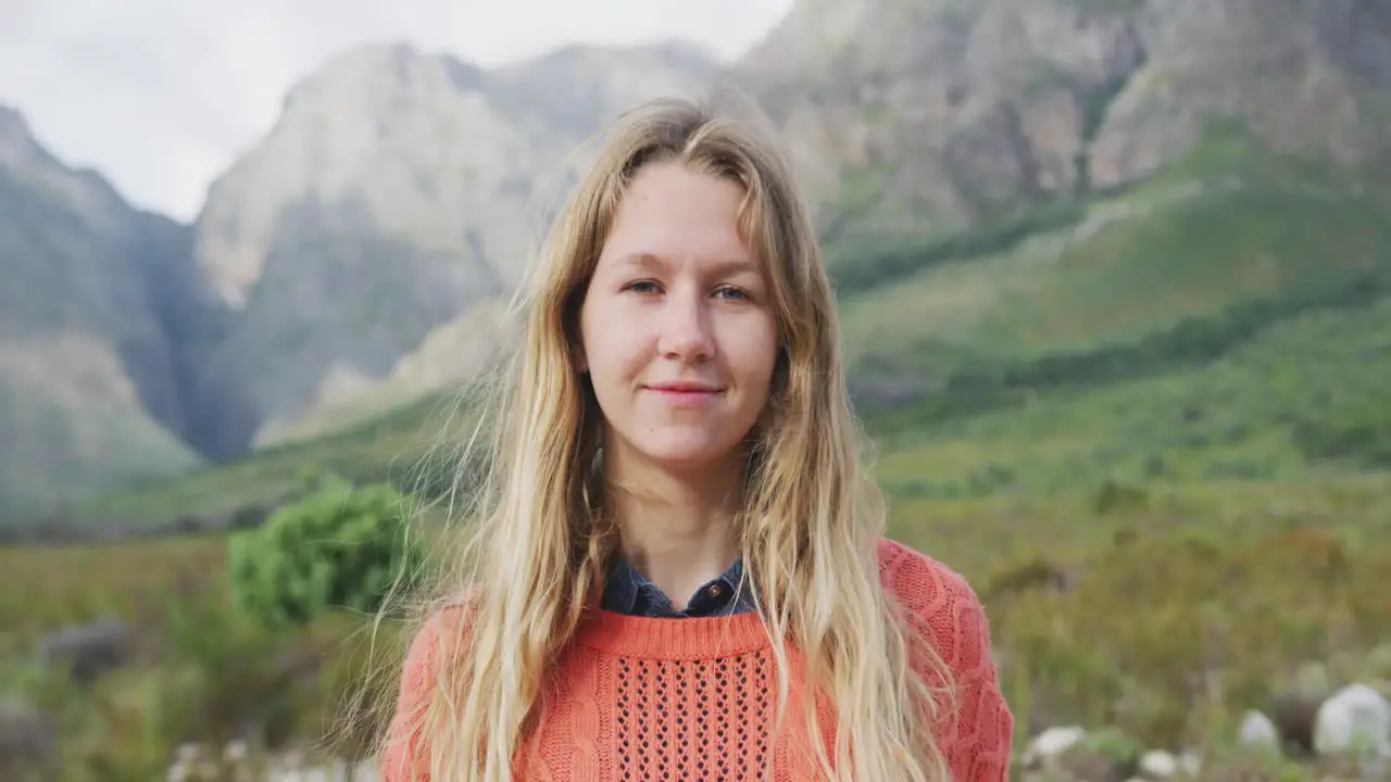 Caucasian woman having a good time on a trip to the mountains looking at camera and smiling