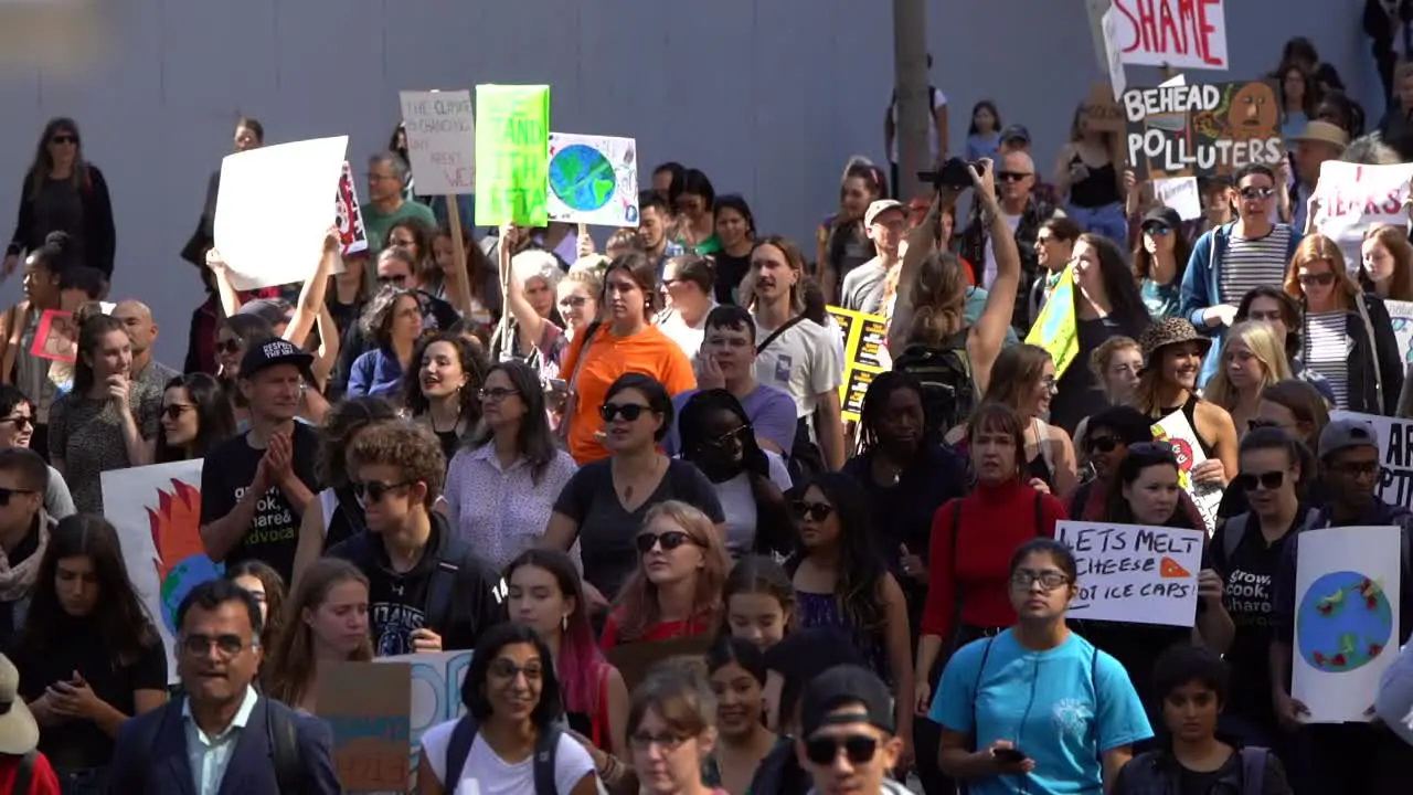 Crowds walking in street protesting global climate change march slow motion