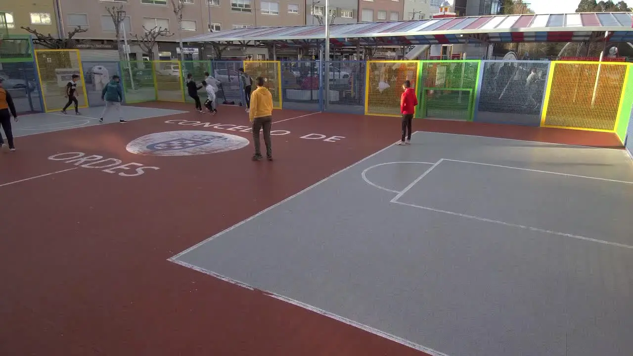 Group Of Boys Playing Cage Football In Urban Park In Ordes In Spain