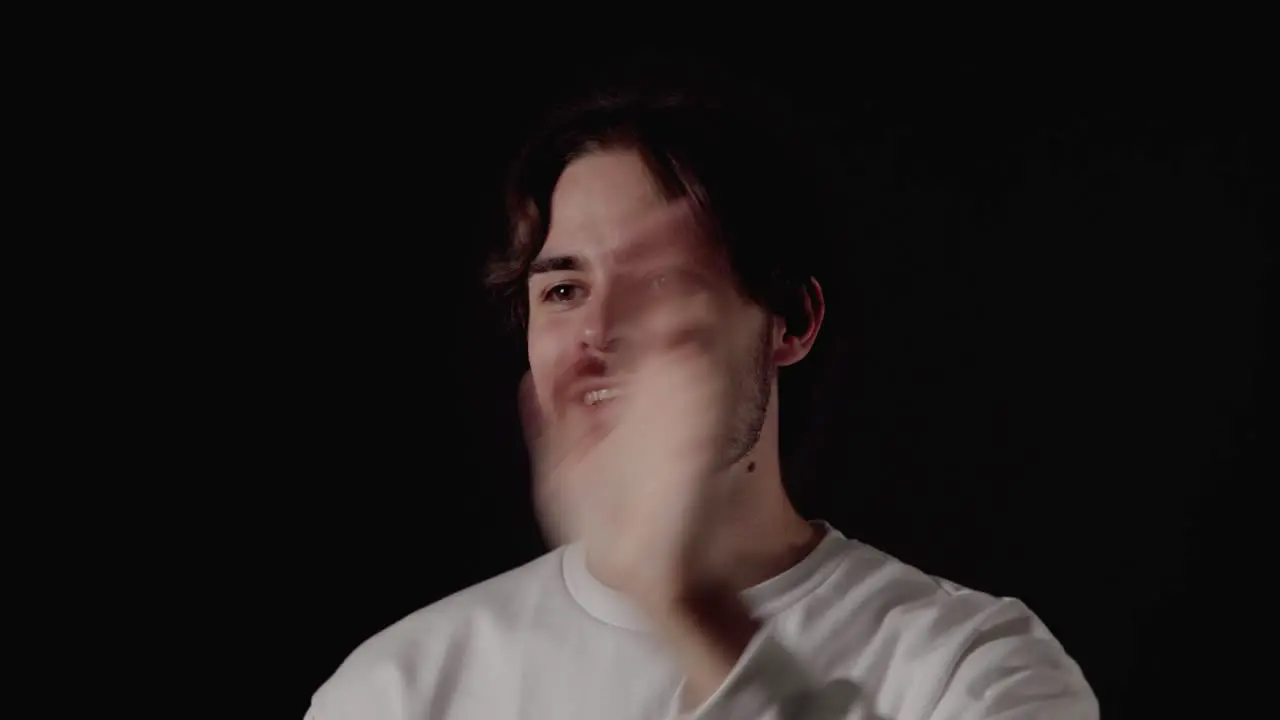 Trendy Young Man waving into camera welcoming gesture close black background