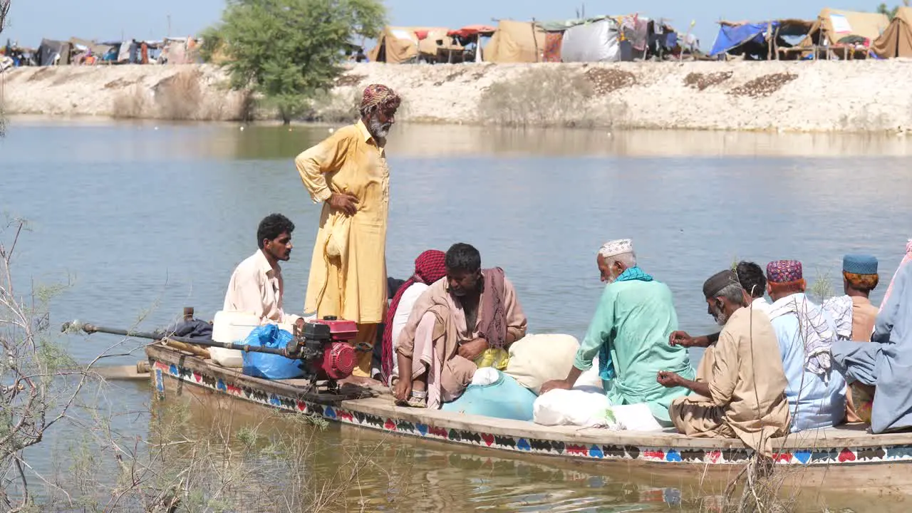 Flood Victims On Boat With Belongings Going Past On River In Sindh