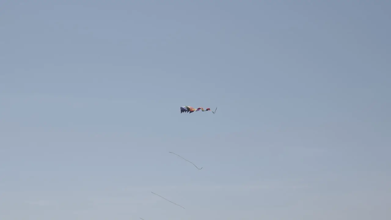 Rainbow gay pride kite flying above beach in California in celebration of pride month