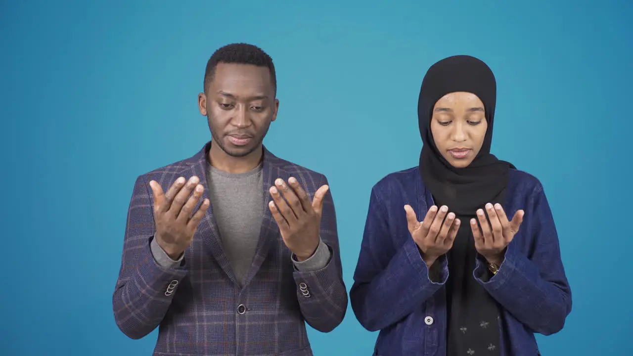 African muslim man and hijab woman praying