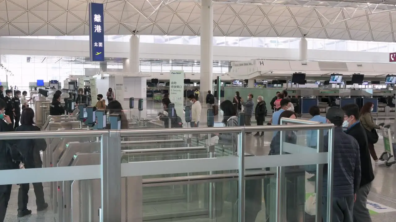 Flight passengers go through security and camera survaillance at the international airport departure hall in Hong Kong