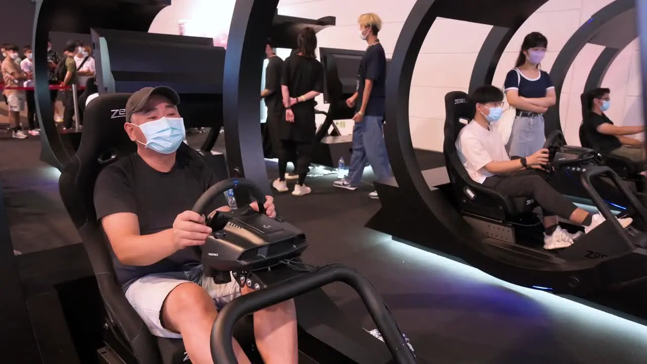 Numerous Chinese gamers play a themed racing videogame as visitors attend the Hong Kong Computer and Communications Festival in Hong Kong