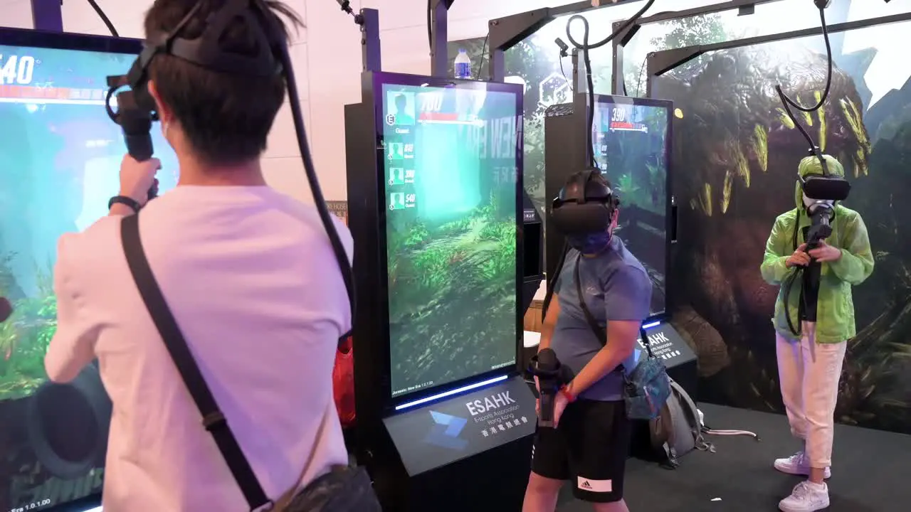 Young Chinese gamers and visitors play Virtual Reality multiplayer shooting videogames during the Hong Kong Computer and Communications Festival in Hong Kong