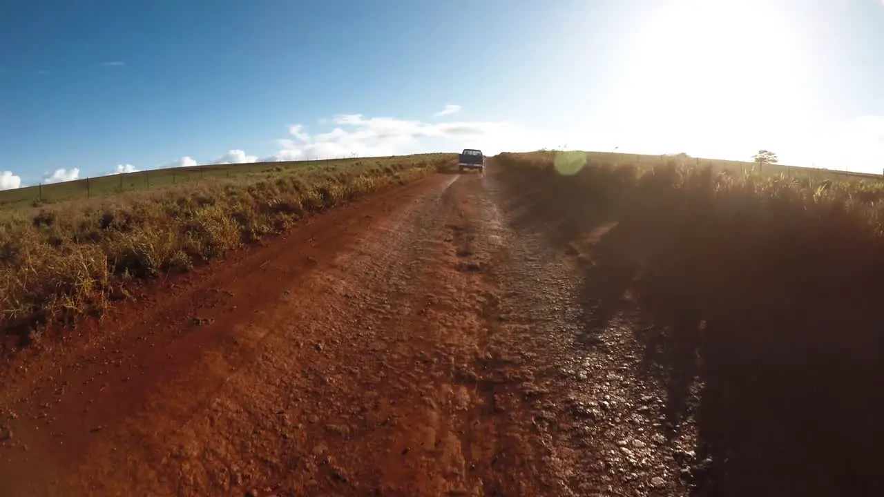 POV from the front of a vehicle following a pickup truck on a very rutted dirt road on Molokai Hawaii from Maunaloa to Hale o Lono