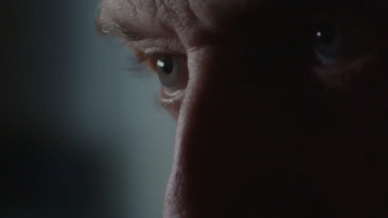 Extreme close-up male eyes in dramatic light as he nods and shakes head