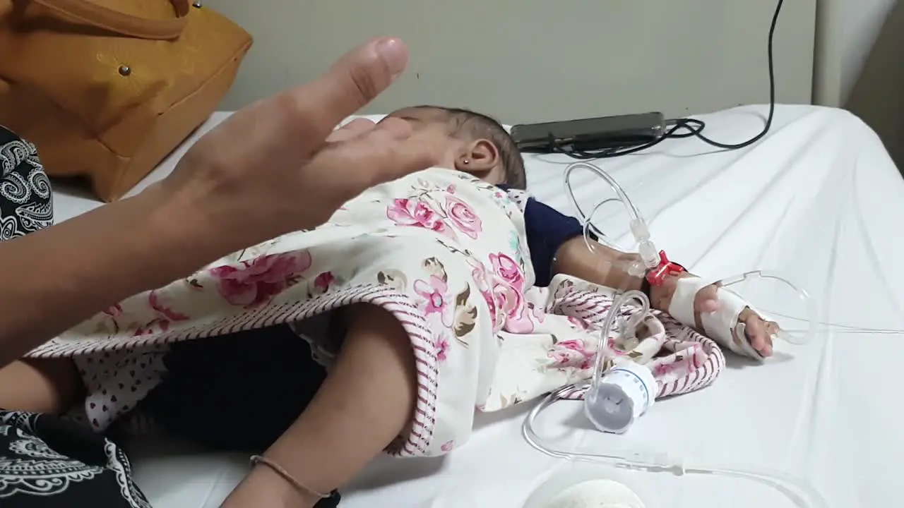 A wounded child with saline and pipes sleeping in a Pakistan hospital