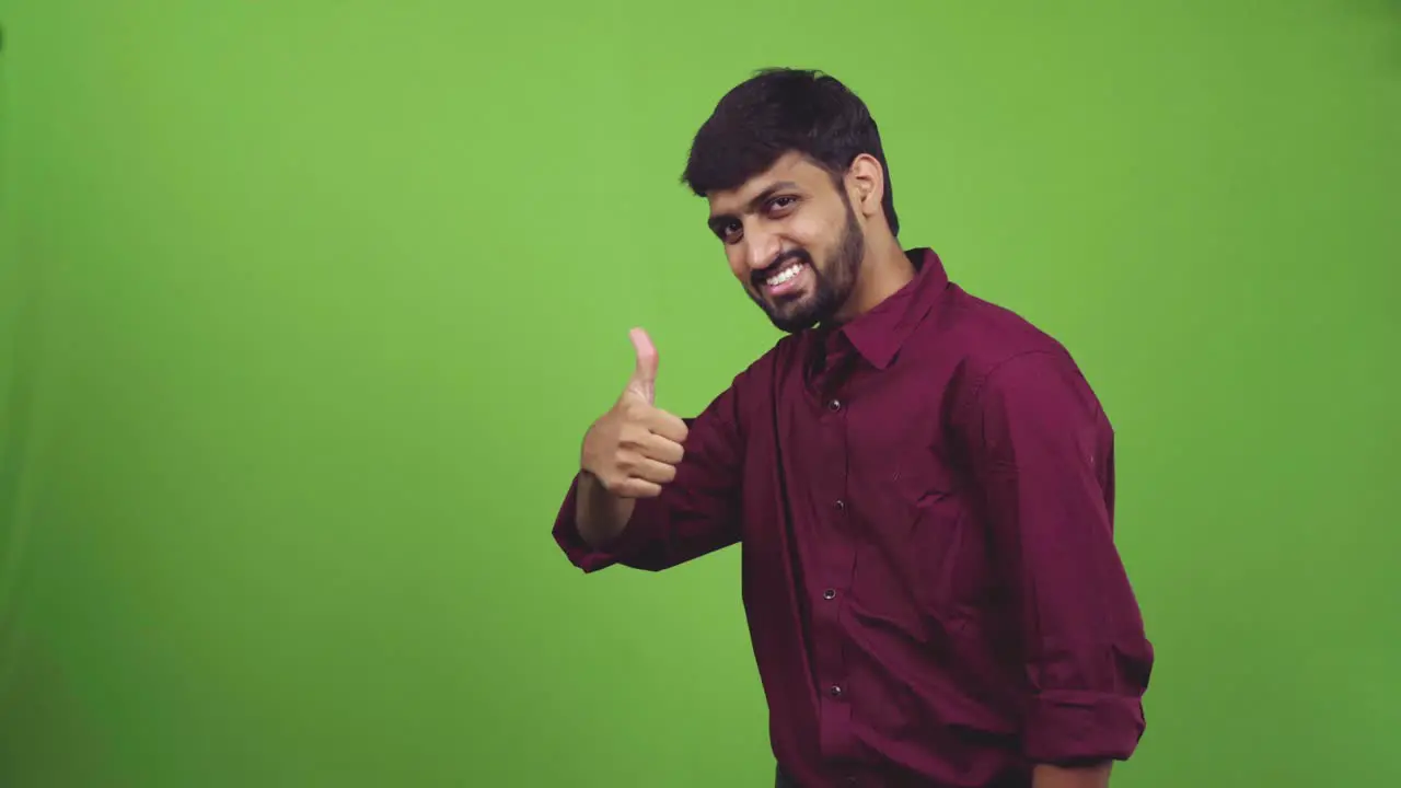 Attractive man showing thumbs up isolated on green screen