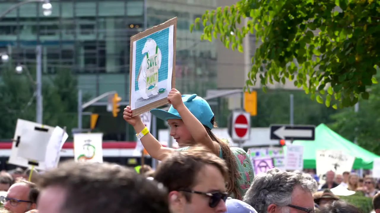 Little girl holding up poster during Global Climate Change March