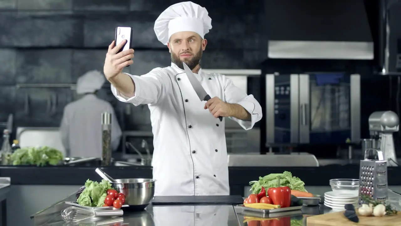 Portrait of Professional chef with knife taking selfie photo