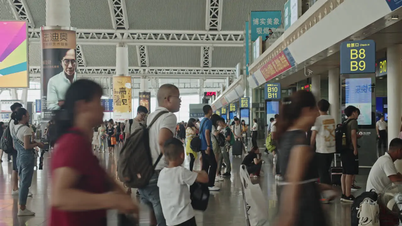 Time-lapse of Guangzhou high speed train South railway station waiting hall with numerous passengers passing by and sitting on the seats Guangzhou China