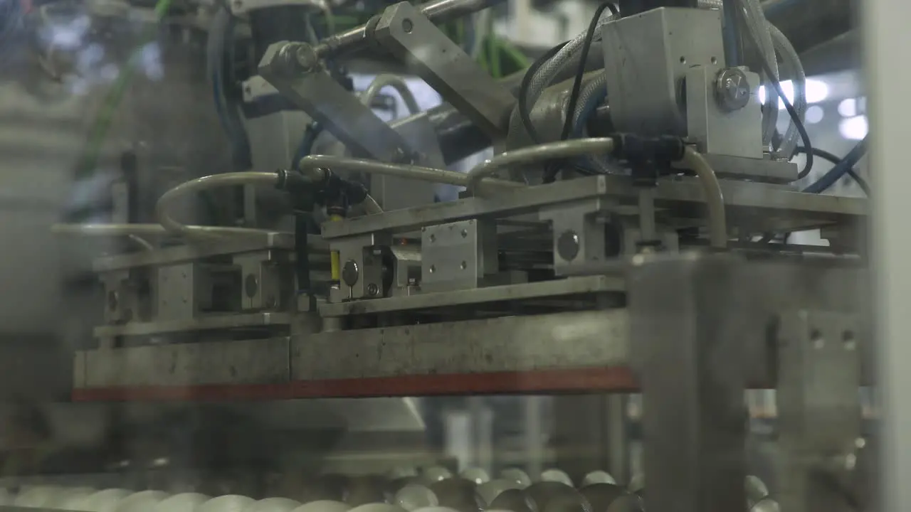 A sorting machine moving into place and sitting idle while factory workers move around