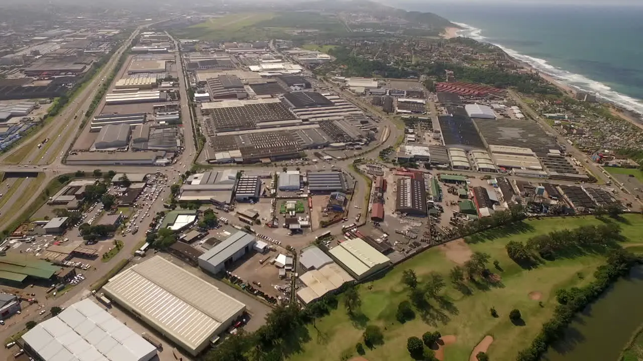 Aerial drone over an industrial area in Durban South Africa showing factories and warehousing alongside the warm Indian Ocean