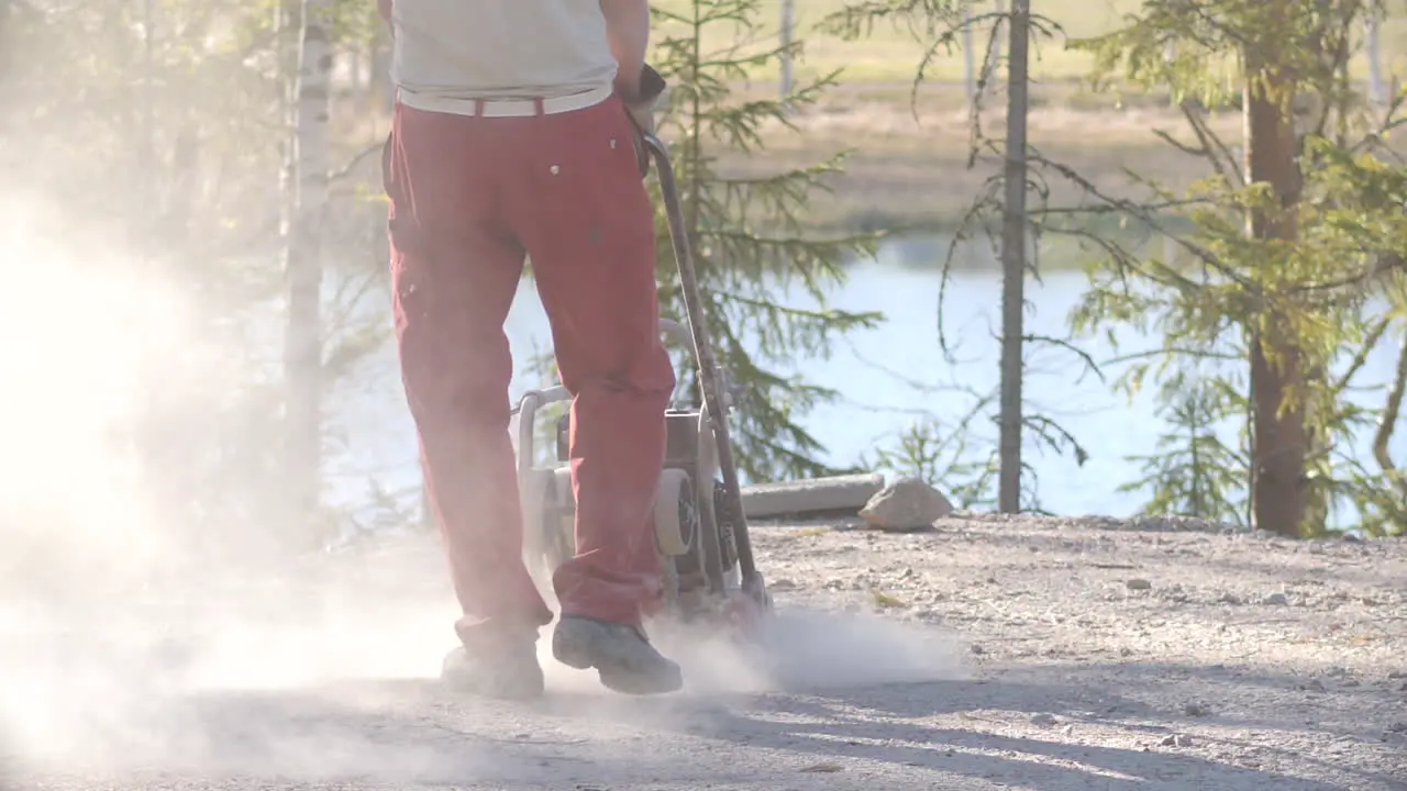 Construction worker using vibratory compactor machine