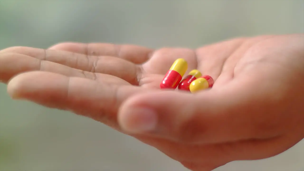 close up of hand received some medicine capsules