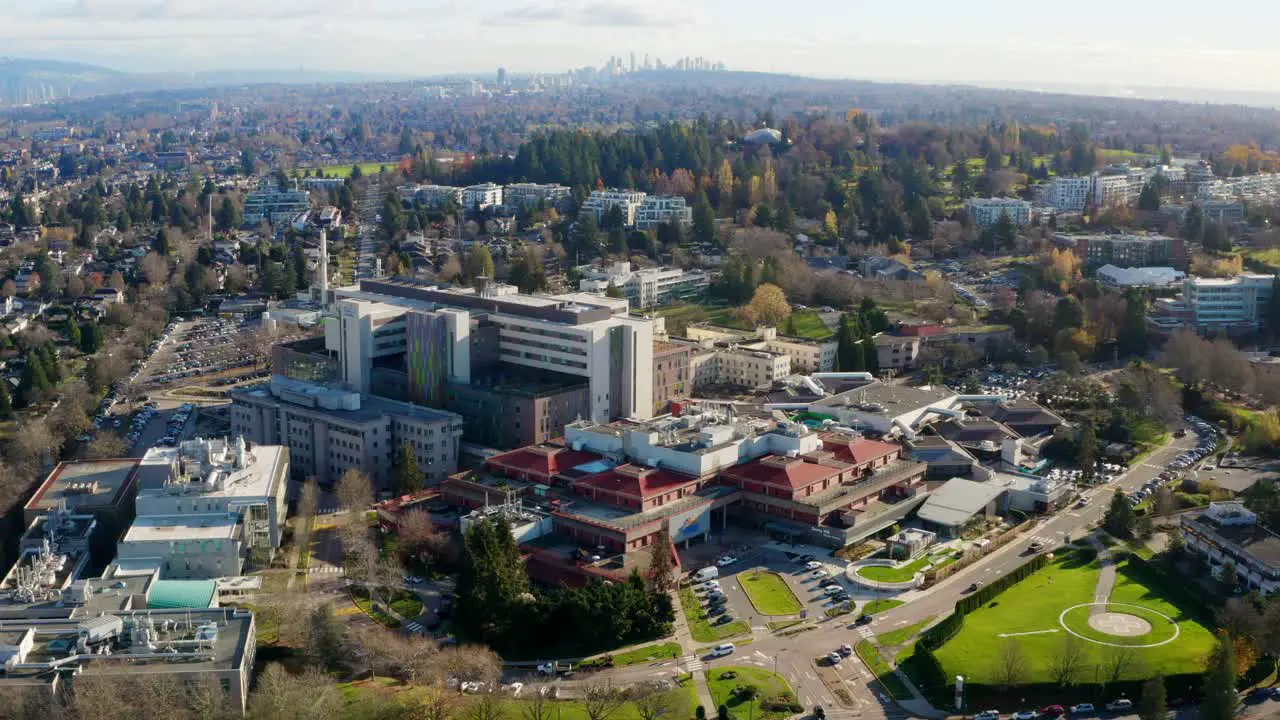 Beautiful Aerial Scene of a Hospital Complex with Healthcare Buildings and an Air Ambulance Helicopter Helipad in UHD on a Sunny Day in Vancouver BC Canada