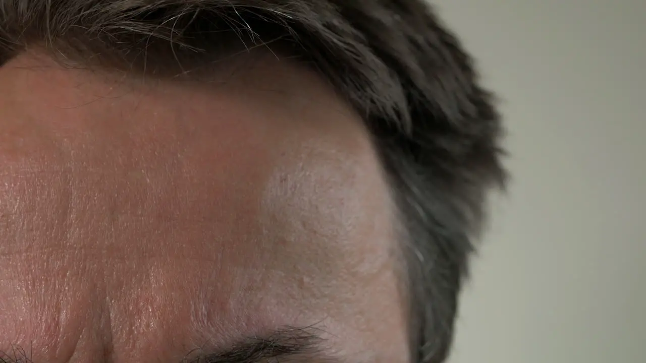 CLOSE UP Man Takes Temperature With Digital Thermometer On Forehead