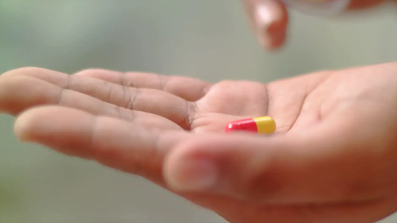 close up hand received one drug capsule