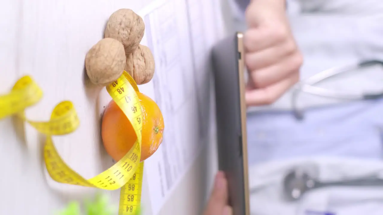 Vertical video diet specialist using a table during a dieting appointment Walnuts and Tangerine on desk