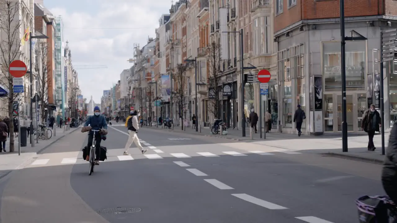 Masked people ride bicycles in the city centre of Leuven Belgium